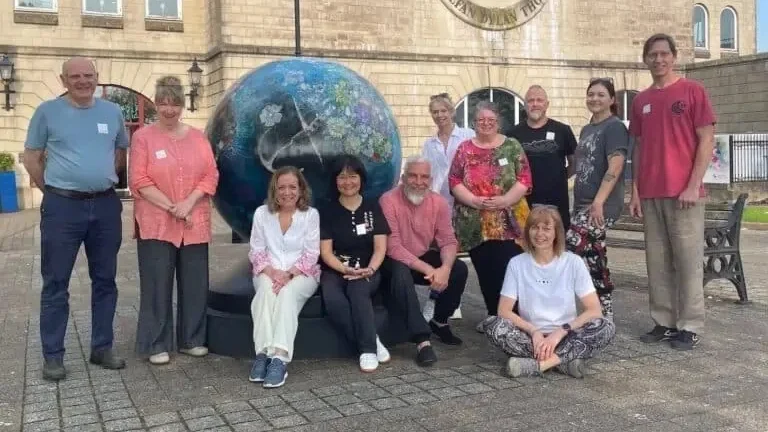 A group of Qi Gong practitioners and teachers together in front of a building