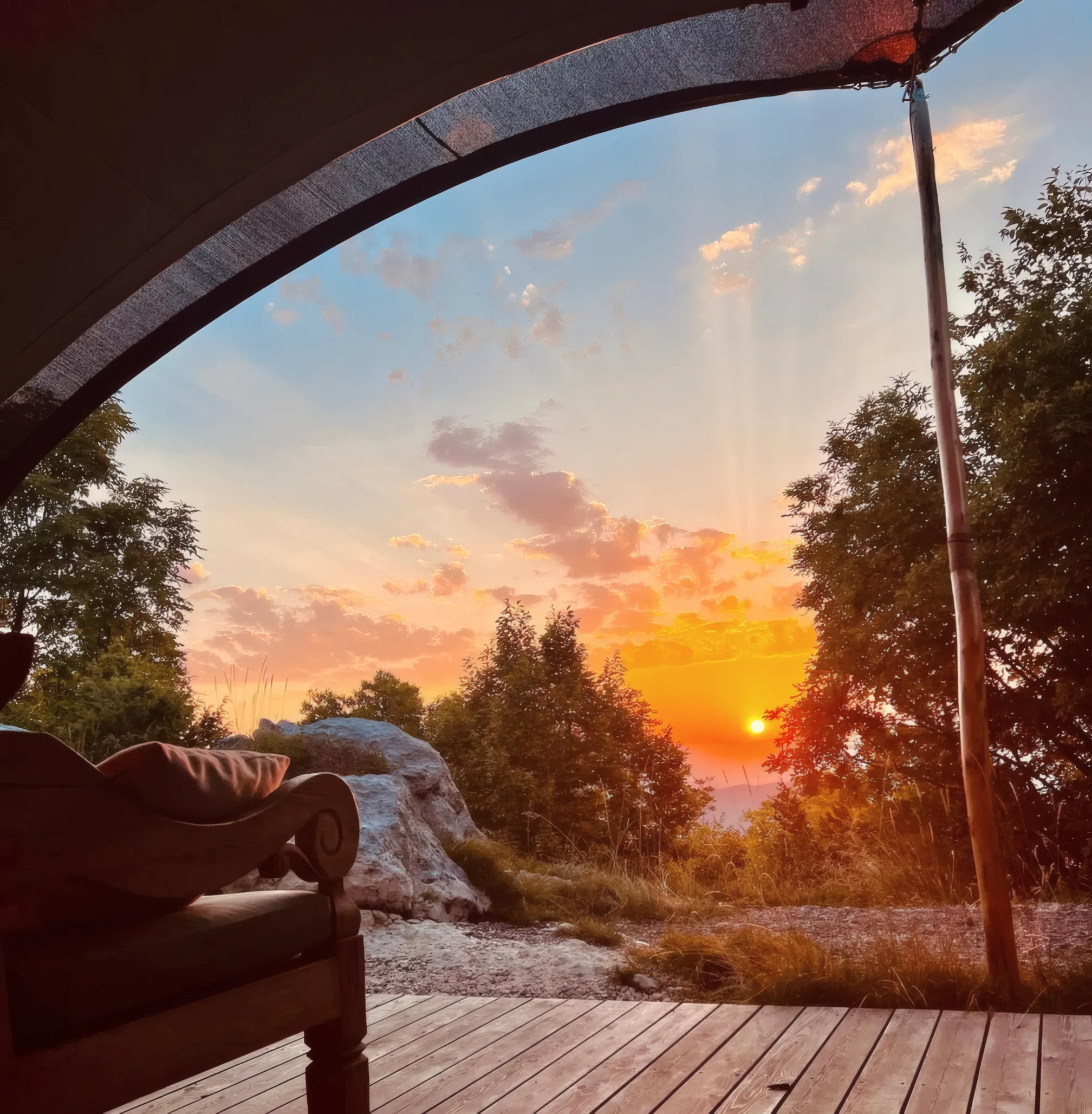 Sunset over the hills, seen from the deck of a glamping house at ašuma retreat