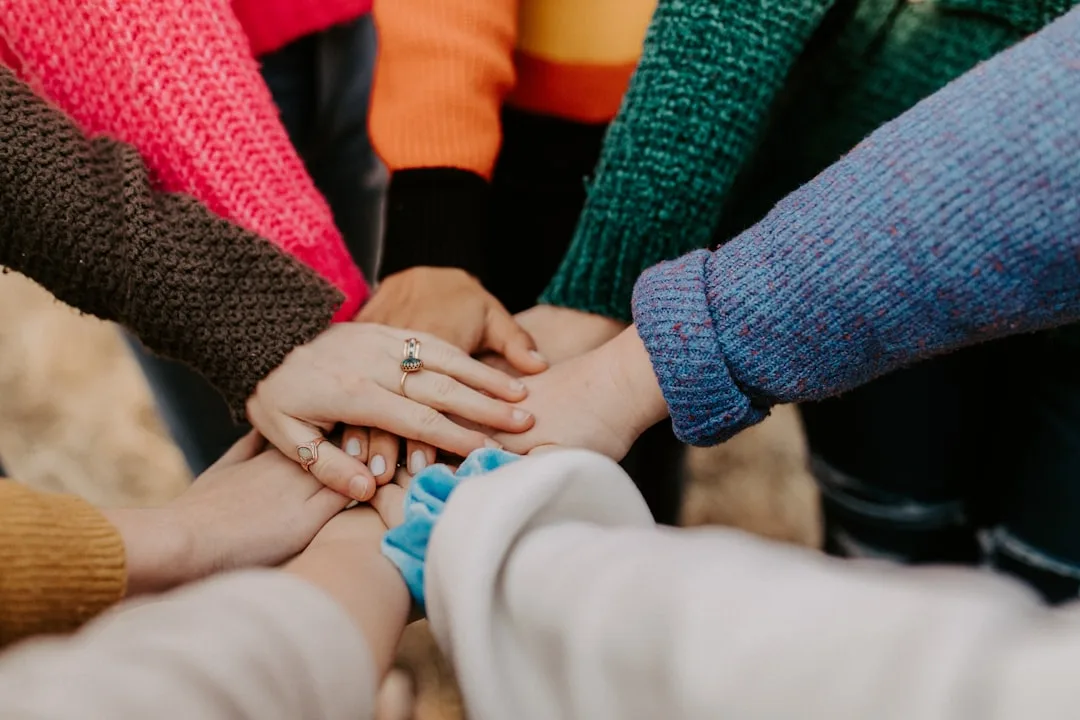 Hands stacked together in the middle of a circle